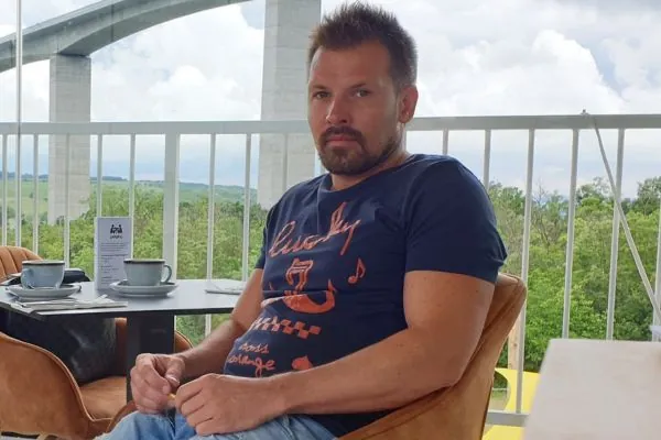 Tóth Lóránt portréja egy terasz asztalánál